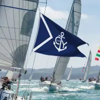 Customizable Burgee Flag flying during a yacht race with anchor design, representing yacht clubs and boating communities.