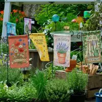 Backyard scene with multiple custom garden flags sets.