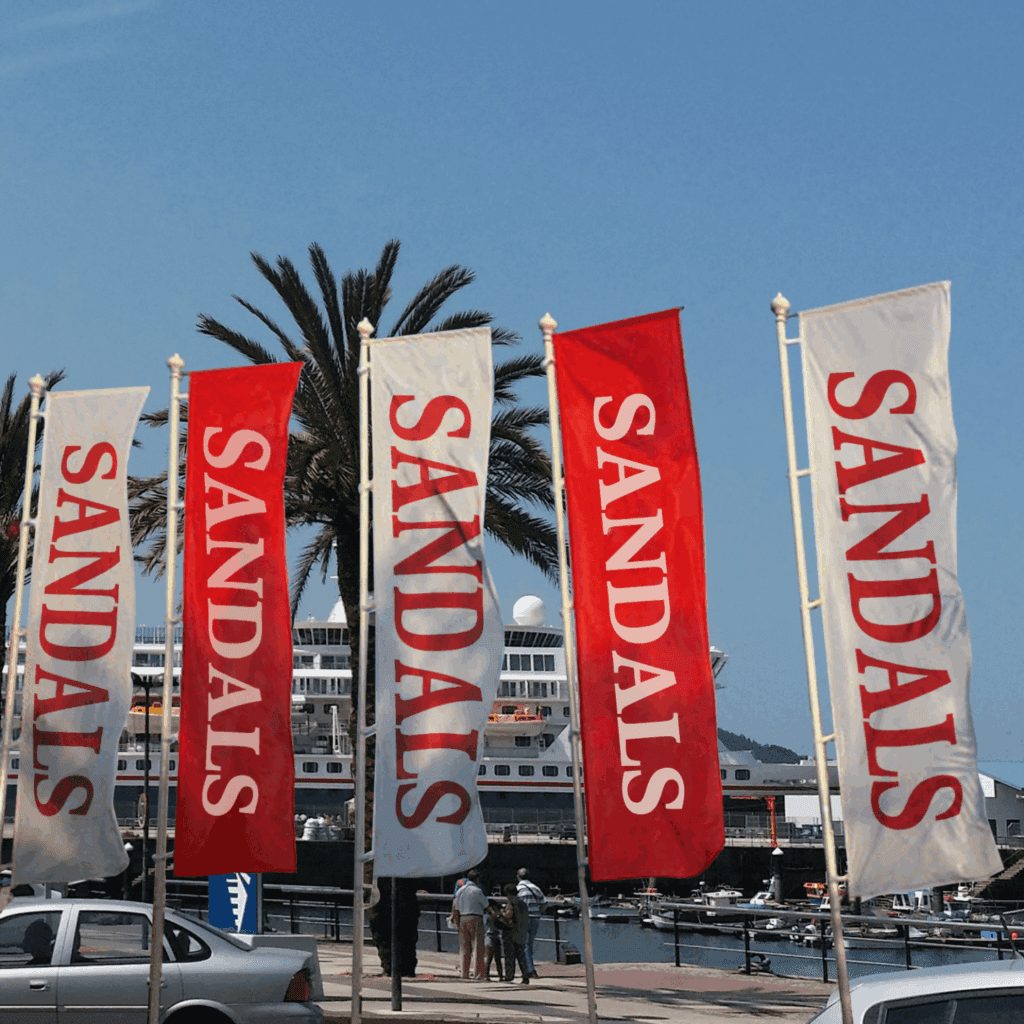 Custom Rectangle Flags | No-Wrinkle & Vibrant Printing 4 Rectangular flags displayed outside a Sandals business for branding
