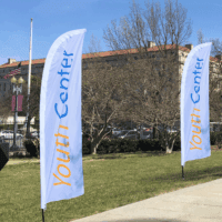 Custom feather flags displayed at a youth center campus event
