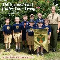 A group of young scouts proudly holding a custom guidon flag with the motto 'We Do Our Best,' symbolizing unity and team spirit.